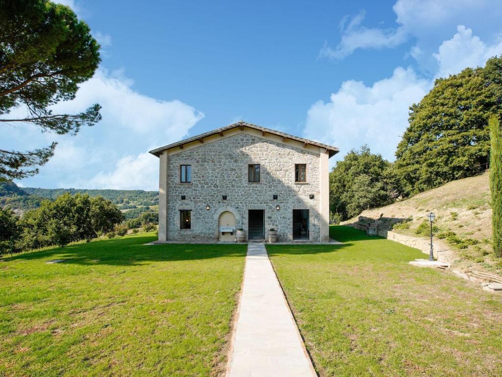 une ancienne maison en pierre sur une colline avec un chemin dans l'établissement Vintage Villa in Sermugnano with Infinity Pool, à Sermugnano