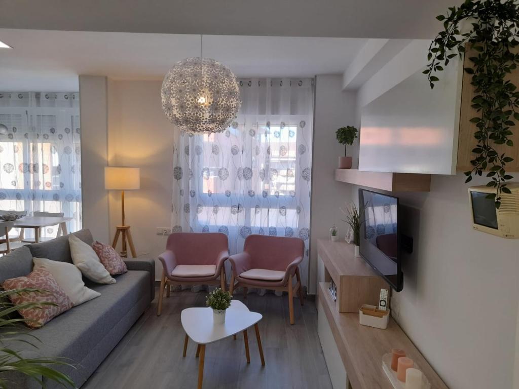 - un salon avec un canapé et une télévision dans l'établissement Apartamento Molinos del Río, à Murcie
