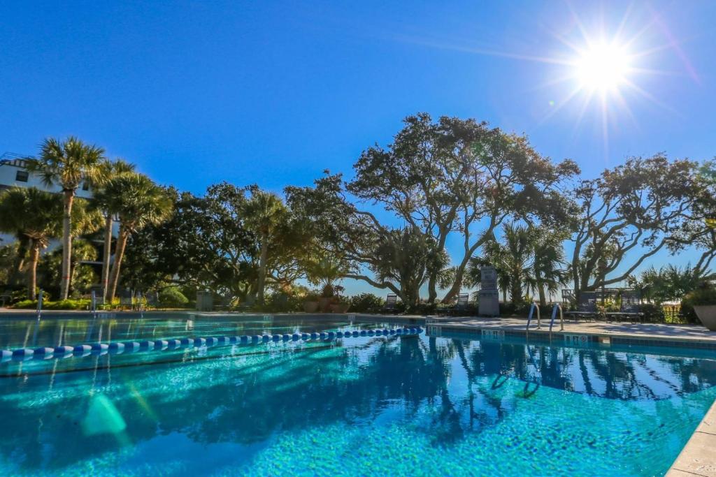 a swimming pool with the sun in the background at Array of Sunshine Condo in Isle of Palms