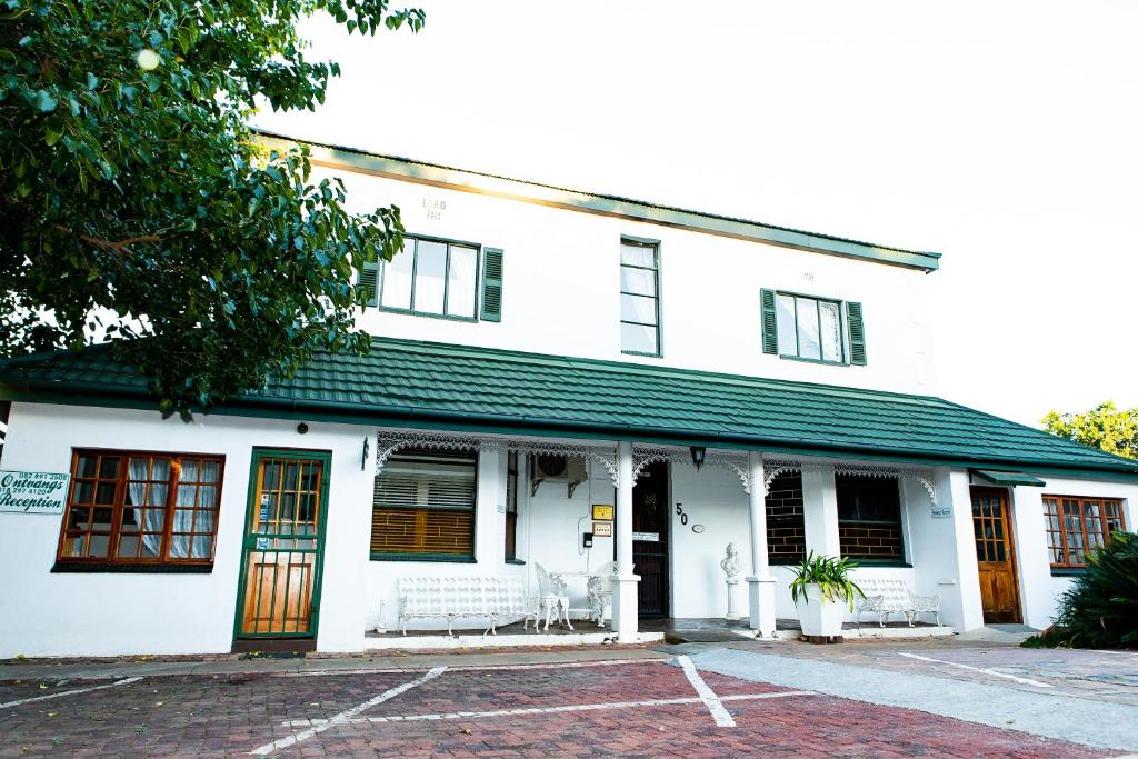 ein weißes Gebäude mit grünem Dach in der Unterkunft Alec Wright's Guest Lodge in Potchefstroom