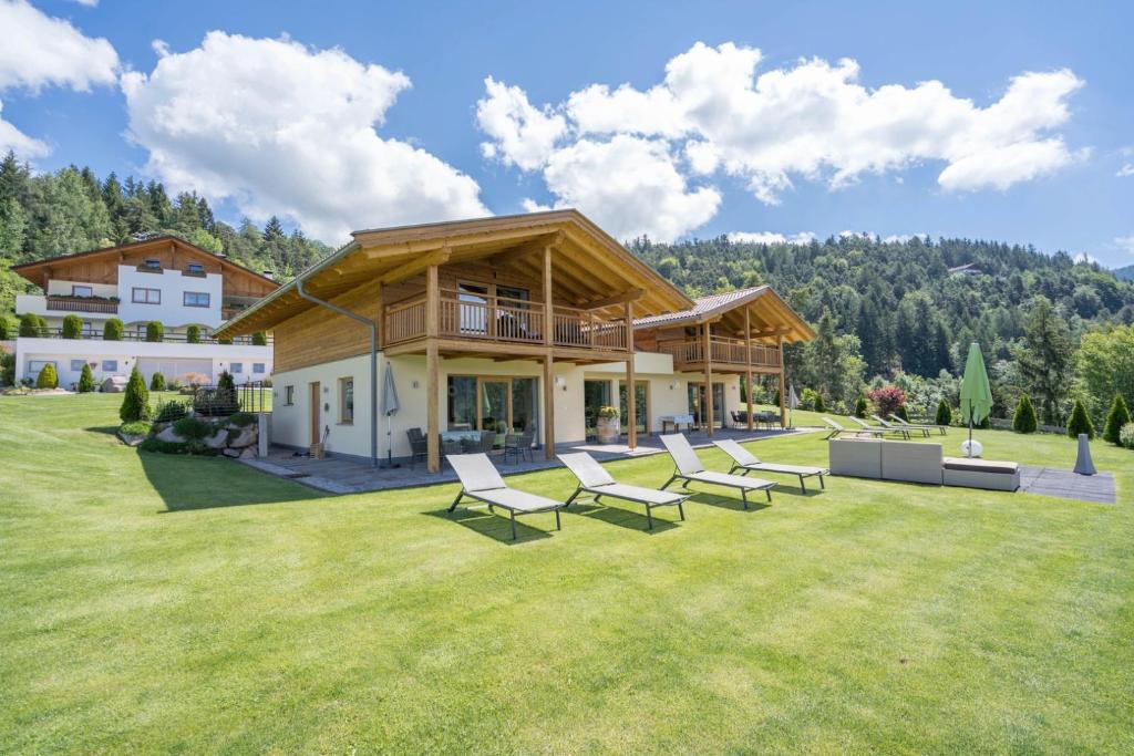 メルティナにあるGasserhof Chaletsのラウンジチェア付きの広い庭のある家