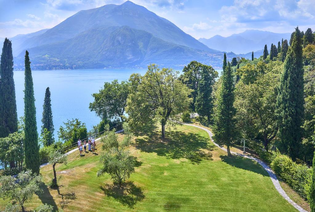 un grupo de personas caminando en una colina cerca de un lago en Agriturismo Castello di Vezio, en Varenna