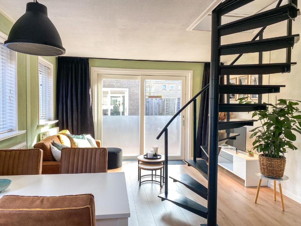 uma sala de estar com uma escada em espiral num quarto em Sfeervolle vakantiewoning Biggekerke BG01 em Biggekerke
