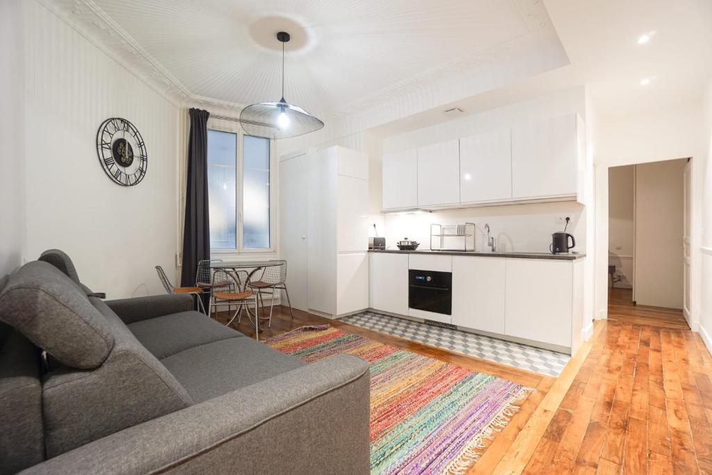 a living room with a couch and a kitchen at Large Flat At 2 Steps From The Eiffel Tower in Paris