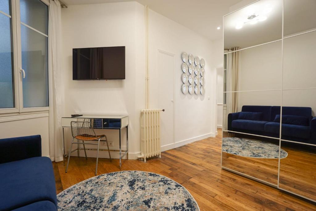 un soggiorno con un divano blu e una TV di Large Flat At 2 Steps From The Eiffel Tower a Parigi