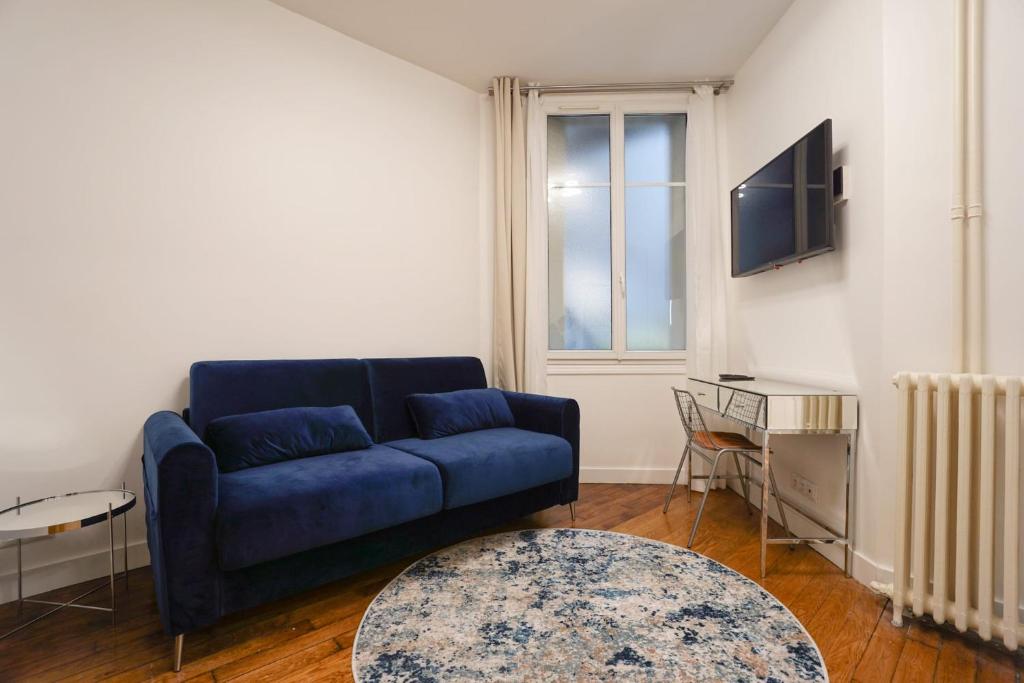 un soggiorno con un divano blu e un tavolo di Large Flat At 2 Steps From The Eiffel Tower a Parigi
