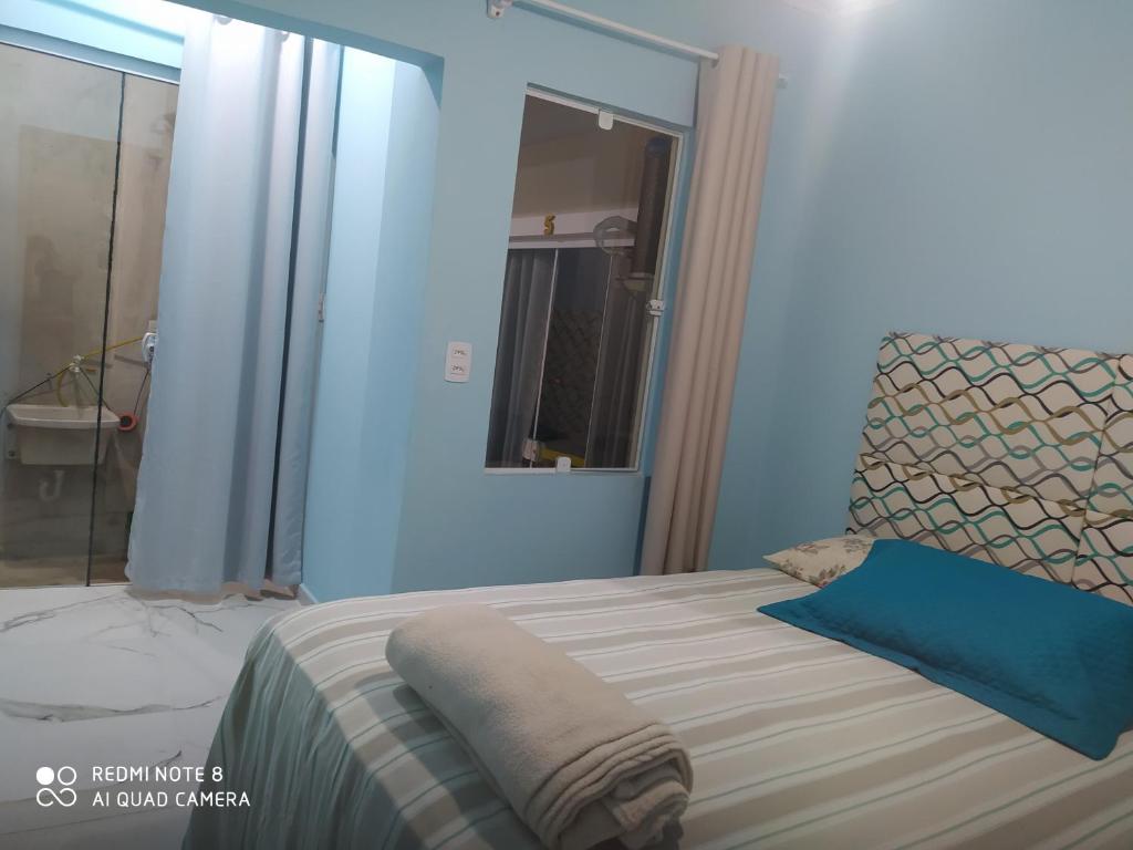 Cantinho da Tia Sandra Suíte 3 في ساو فرانسيسكو دو سول: غرفة نوم بسرير مع جدار ازرق