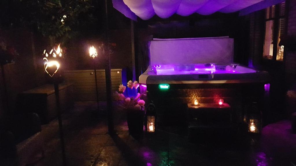 ciemny pokój z łóżkiem z fioletowymi światłami w obiekcie Whirlpool Suite Marrakesch-Lounge w mieście Stelle