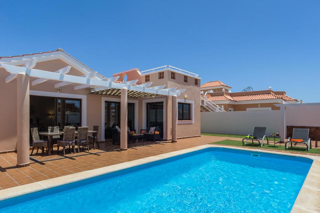 a villa with a swimming pool and a house at Villa with private pool, near beach and golf Caleta de Fuste- Villa Charlotte in Costa de Antigua