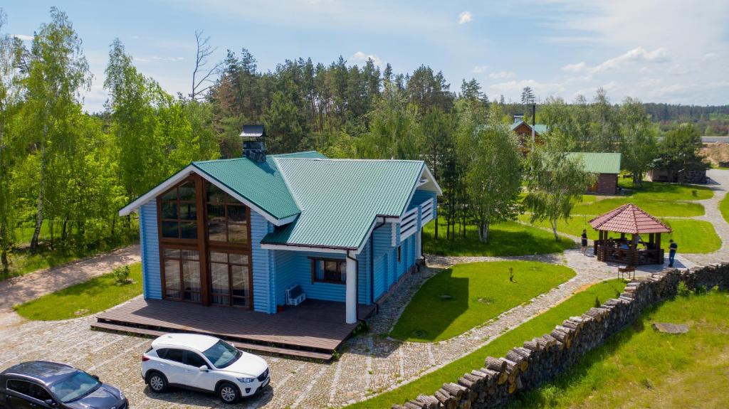 a small blue house with a car parked in front at Lake House Стрижевка in Strizhevka