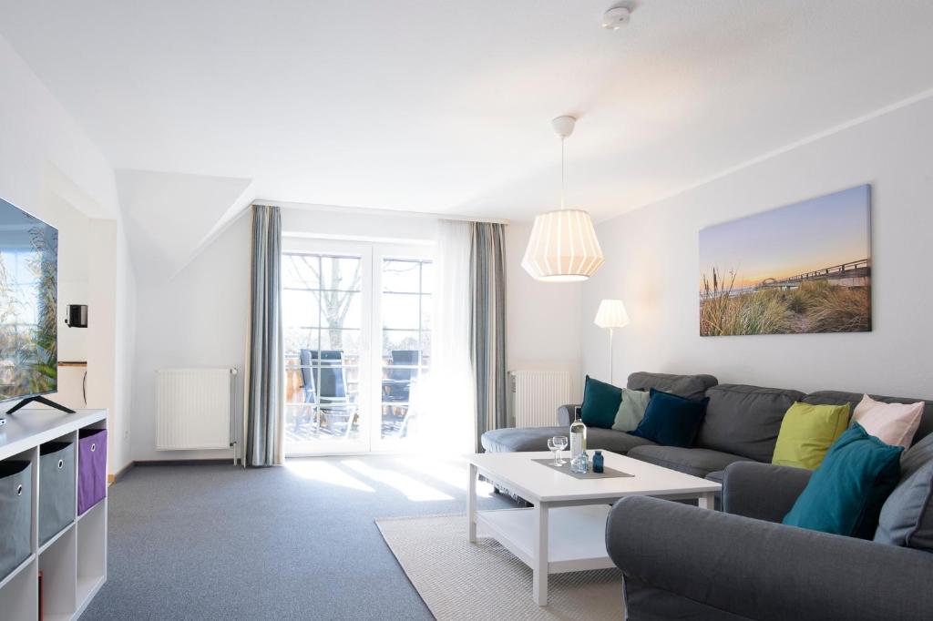 een woonkamer met een bank en een tafel bij Apartmenthaus Tiemann Wohnung 3 in Kellenhusen