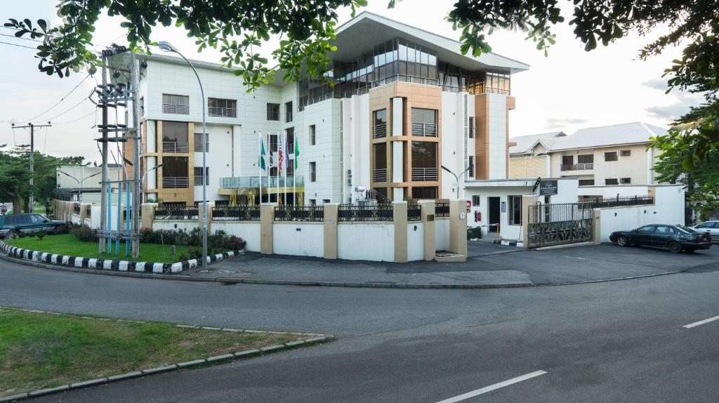 a large white building with a car parked in front of it at Qualibest Grand Hotels in Abuja