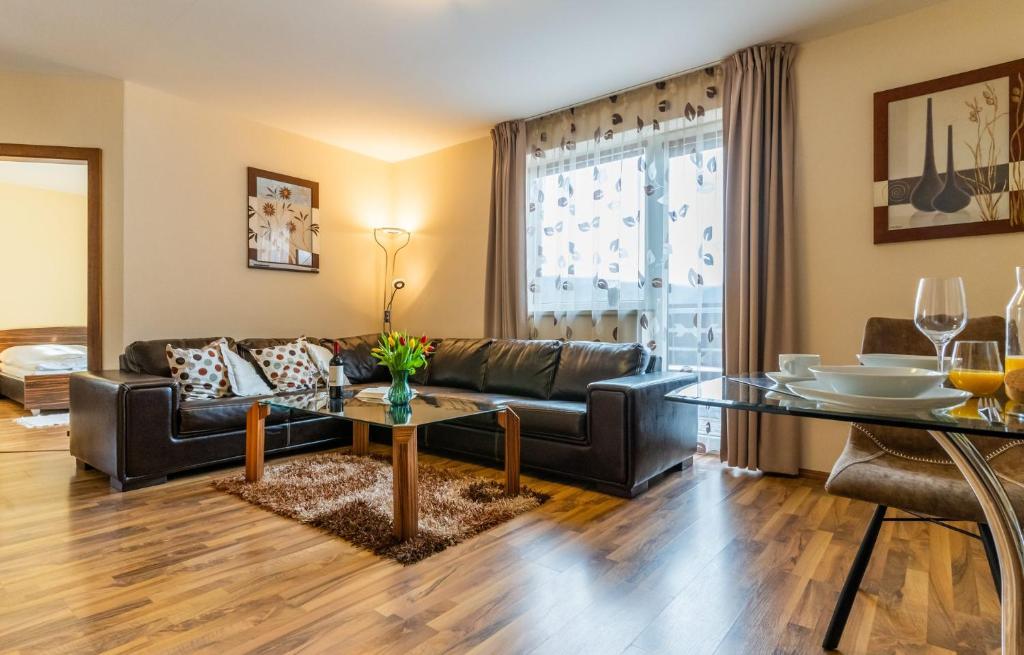 a living room with a leather couch and a table at Central Apartment in Donovaly