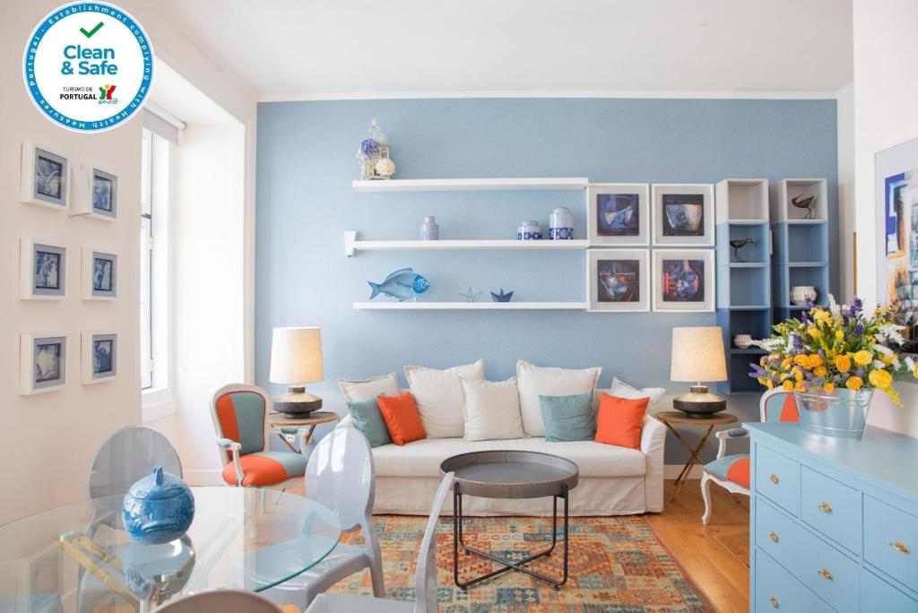 uma sala de estar com paredes azuis e um sofá branco em Rent4Rest - Lisbon Downtown Designer's Apartment em Lisboa