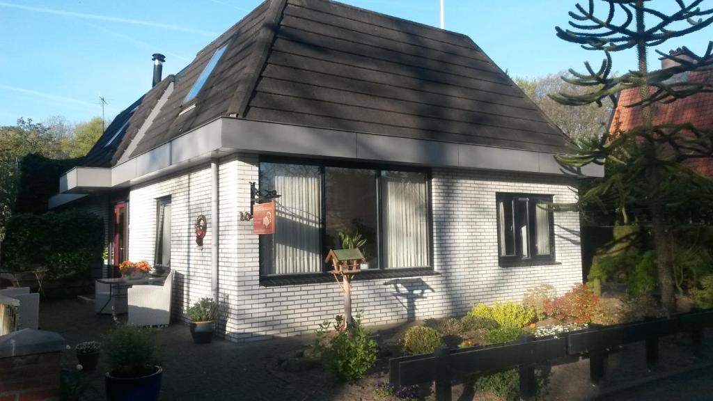 a small white house with a black roof at B&B Harskamp in Harskamp