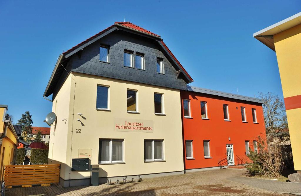 a house with a black roof on a street at Lausitzer Ferienapartments in Bernsdorf