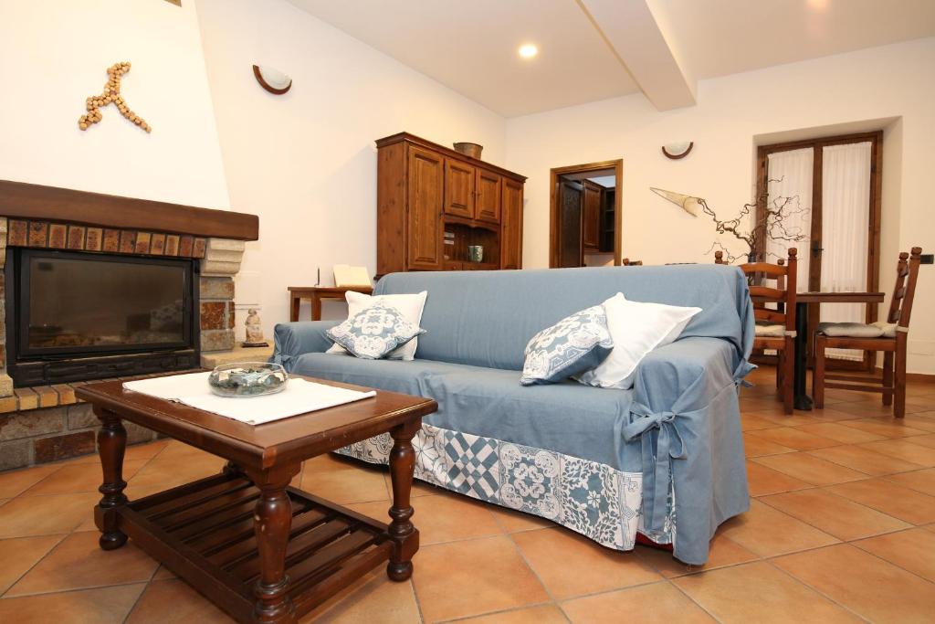 a living room with a blue couch and a coffee table at Mella Bellagio Al Porto - Appartamento con Terrazze a pochi passi dal Lago in Bellagio