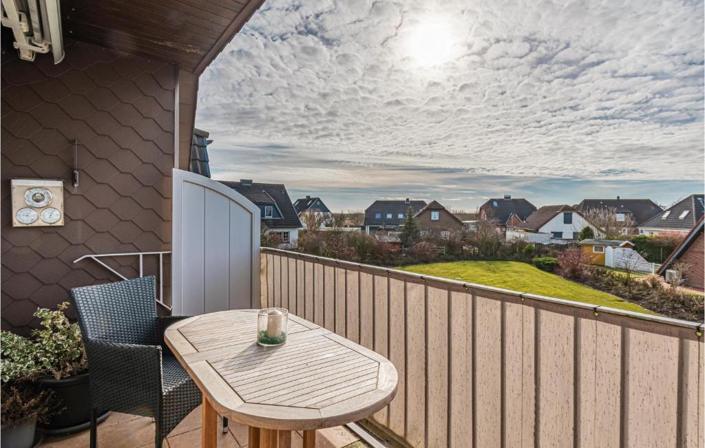 d'une terrasse avec une table et des chaises en bois sur un balcon. dans l'établissement Amazing Apartment In Friedrichskoog With Kitchen, à Friedrichskoog-Spitz