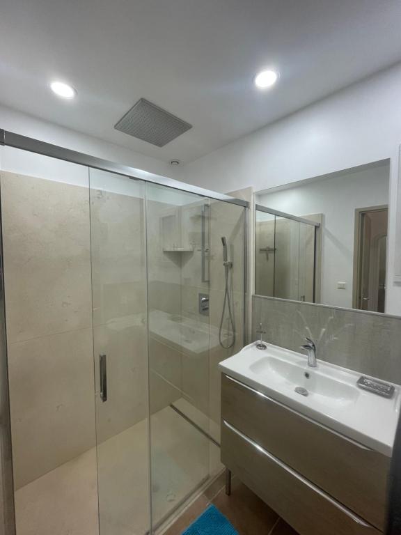 Un baño con ducha de cristal y lavabo. en Le Mazet De Lélé, en Saint-Rémy-de-Provence