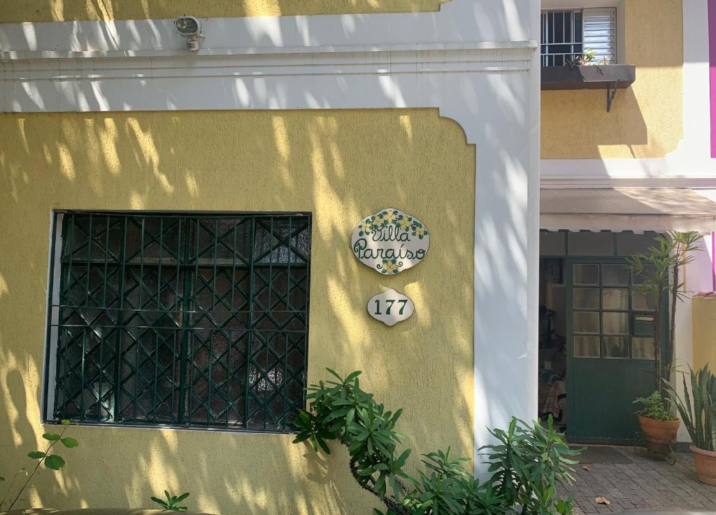 um edifício amarelo com um sinal na lateral em Villa Paraíso em São Paulo