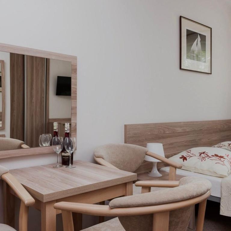 a living room with a table and chairs and a bed at Willa Portowa - 120 metrów od plaży in Dziwnów