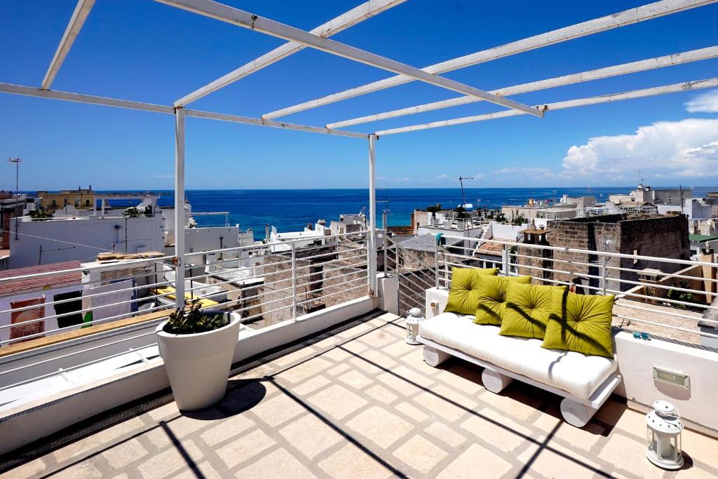 a balcony with a couch and a view of the ocean at Elamar Rooms & Apartment in Gallipoli