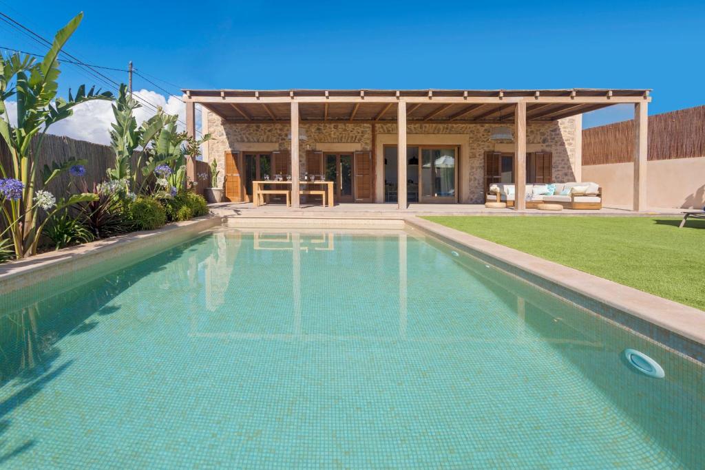 a swimming pool in front of a house at Villa Can Ginebra in Sant Josep de sa Talaia