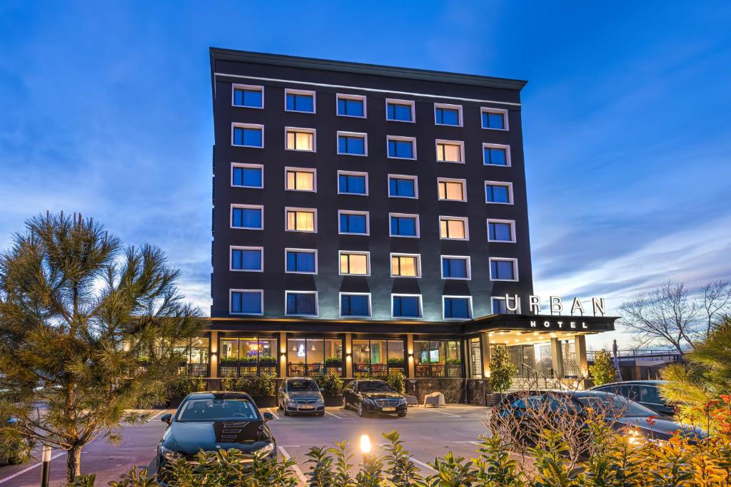 a hotel with cars parked in a parking lot at Hotel Urban in Plovdiv