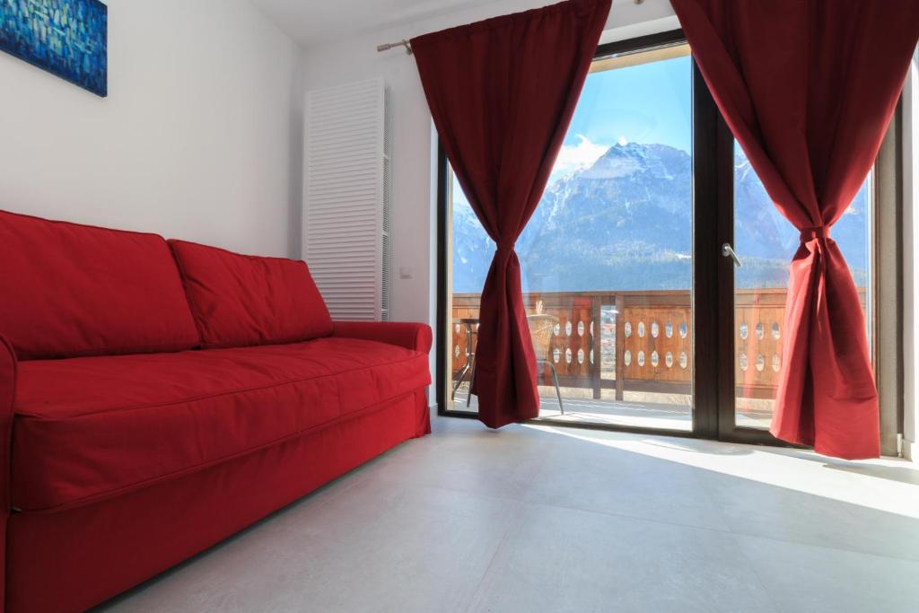 a red couch in a room with a view of a mountain at Stars & Mountain Apartment in Buşteni
