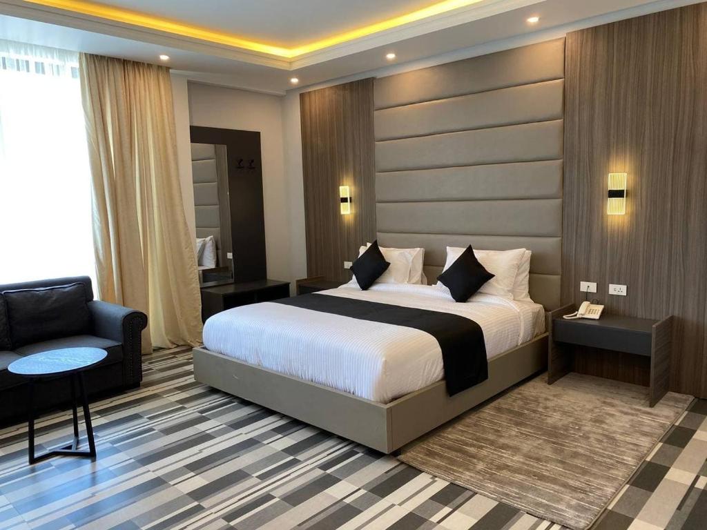 亚的斯亚贝巴ECCO Modern Guest House的一间带床和椅子的酒店房间