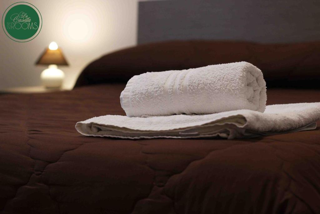 una pila de toallas sentadas encima de una cama en La Casetta, en Palermo