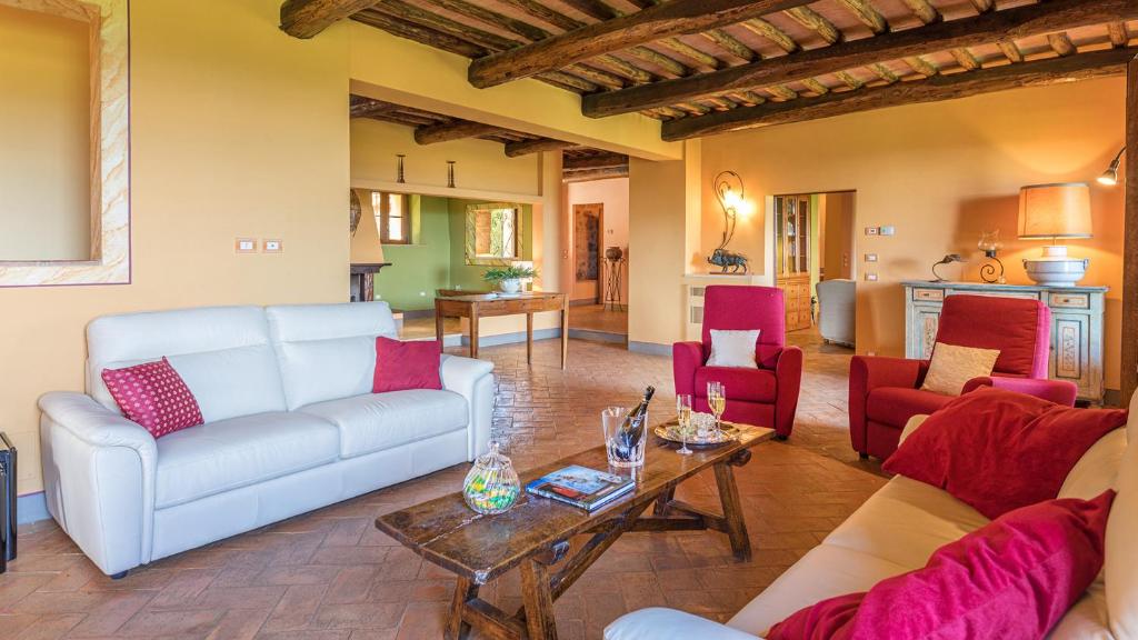salon z białą kanapą i czerwonymi krzesłami w obiekcie VILLA IL FORAMASSO 10&2, Emma Villas w mieście Lucciana