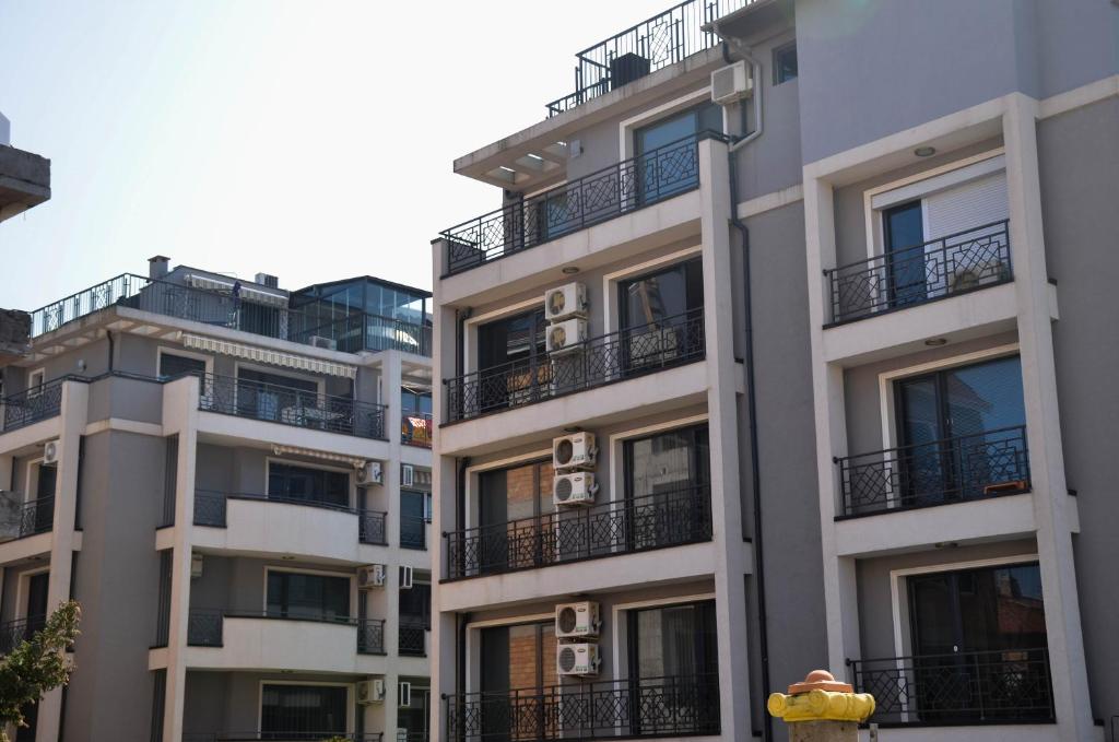 a tall building with balconies and a fire hydrant at Belchevi Apartments in Burgas City