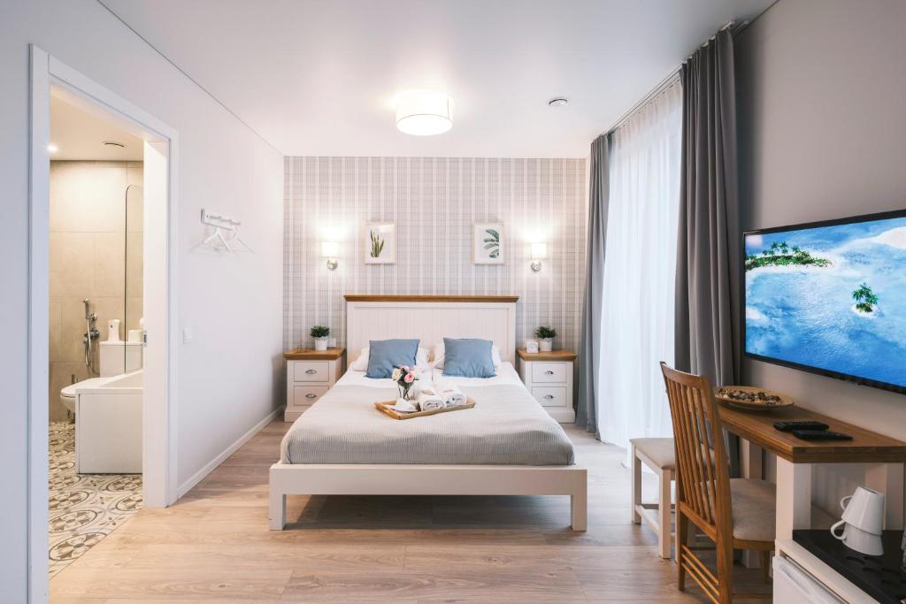 a bedroom with a bed and a tub and a television at Real House Jasinskio WEB-APP SELF CHECK-IN in Vilnius