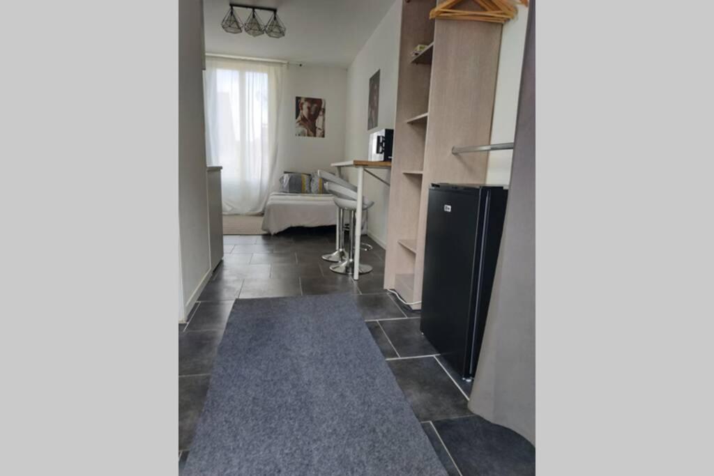 a living room with a kitchen and a table at Studio Cosy et fonctionnel drancy CDG in Drancy