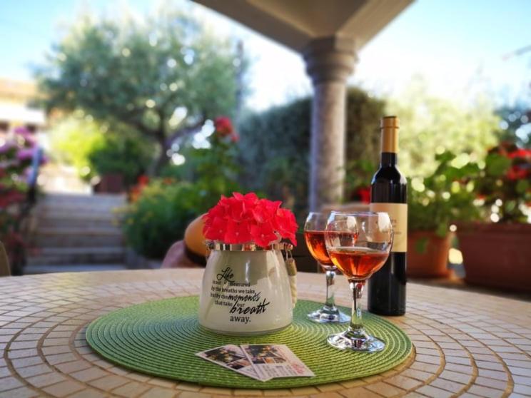 un tavolo con una bottiglia di vino e un bicchiere di Apartmani Rita Kiwi a Novigrad Istria