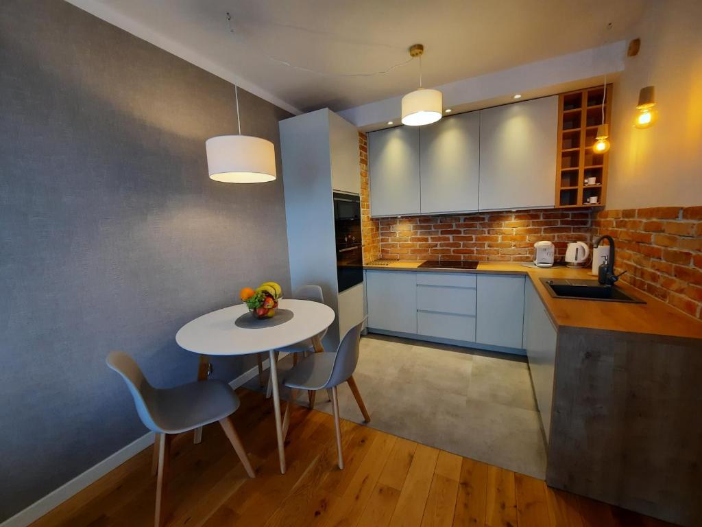 uma cozinha com mesa e cadeiras num quarto em Bastion Apartment Gdansk City Center em Gdansk