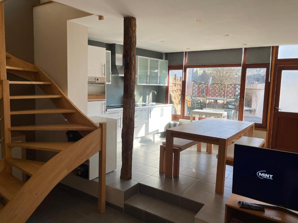 a kitchen and living room with a staircase and a table at Appartement au Centre de Stavelot in Stavelot