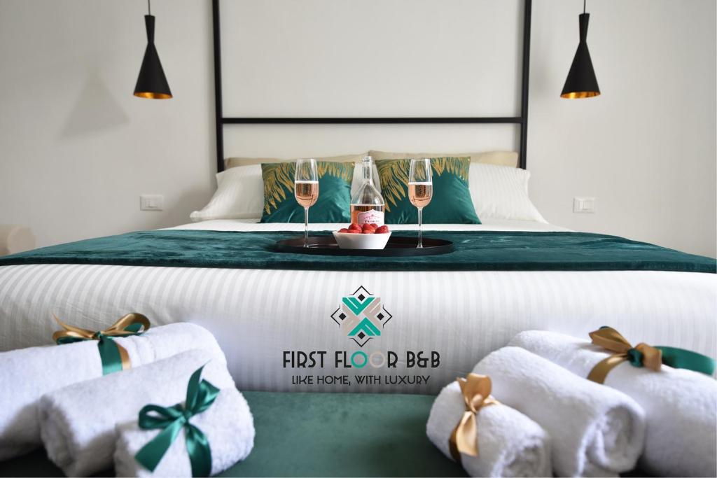 a bedroom with a bed with two glasses of champagne at First Floor B&B in Bari