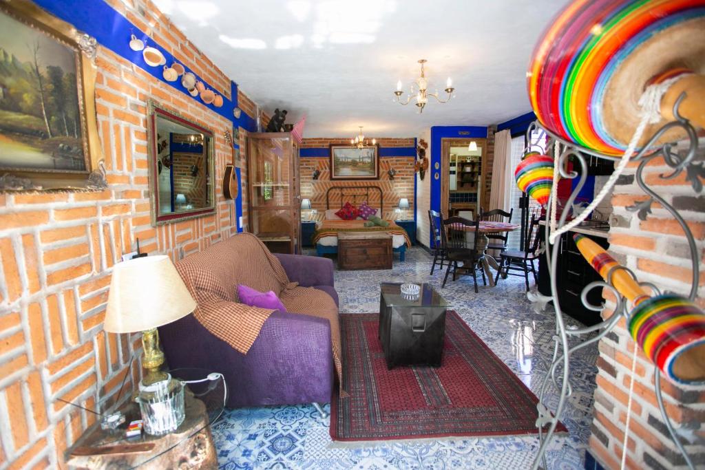 a living room with a couch and a brick wall at Majikal B&B - Diego Rivera in Cholula