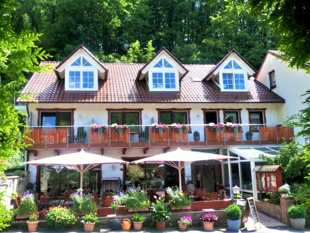 ein großes Haus mit Sonnenschirmen davor in der Unterkunft Landhotel Fasanenhof in Eschwege