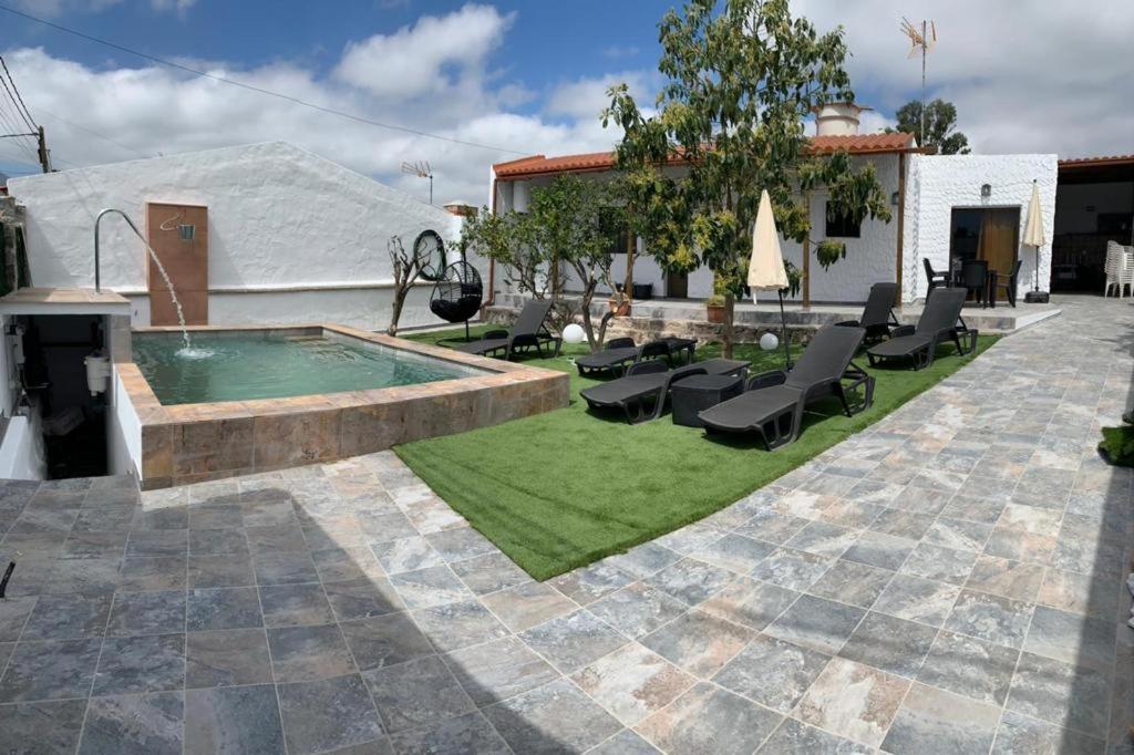 une terrasse avec une piscine et des chaises ainsi qu'une maison dans l'établissement Casa Juani, à Las Palmas de Gran Canaria