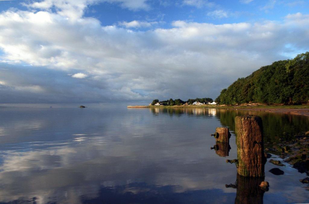 a body of water with a wooden post in the water at The Bay Horse Hotel And Restaurant in Ulverston