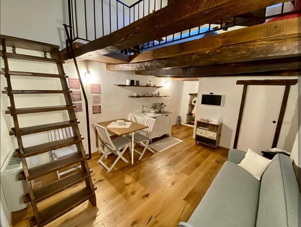 a living room with a staircase and a table and a couch at B&B e Home Restaurant S'ispera Monolocale uso esclusivo in Fonni