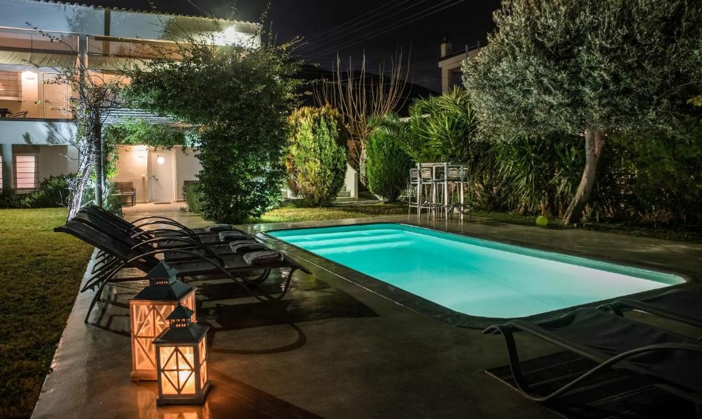 a swimming pool in a yard at night at Nataly's Gardens with Pool Lagonissi in Lagonissi