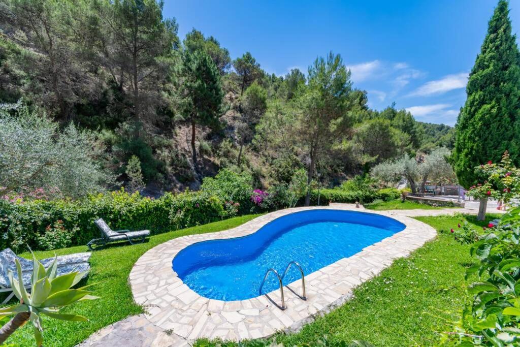 a swimming pool in the middle of a yard at Casa Rosa, con encanto y piscina climatizada in Frigiliana