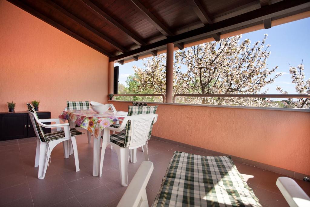 a balcony with a table and chairs and a window at Apartment Relax in Fažana