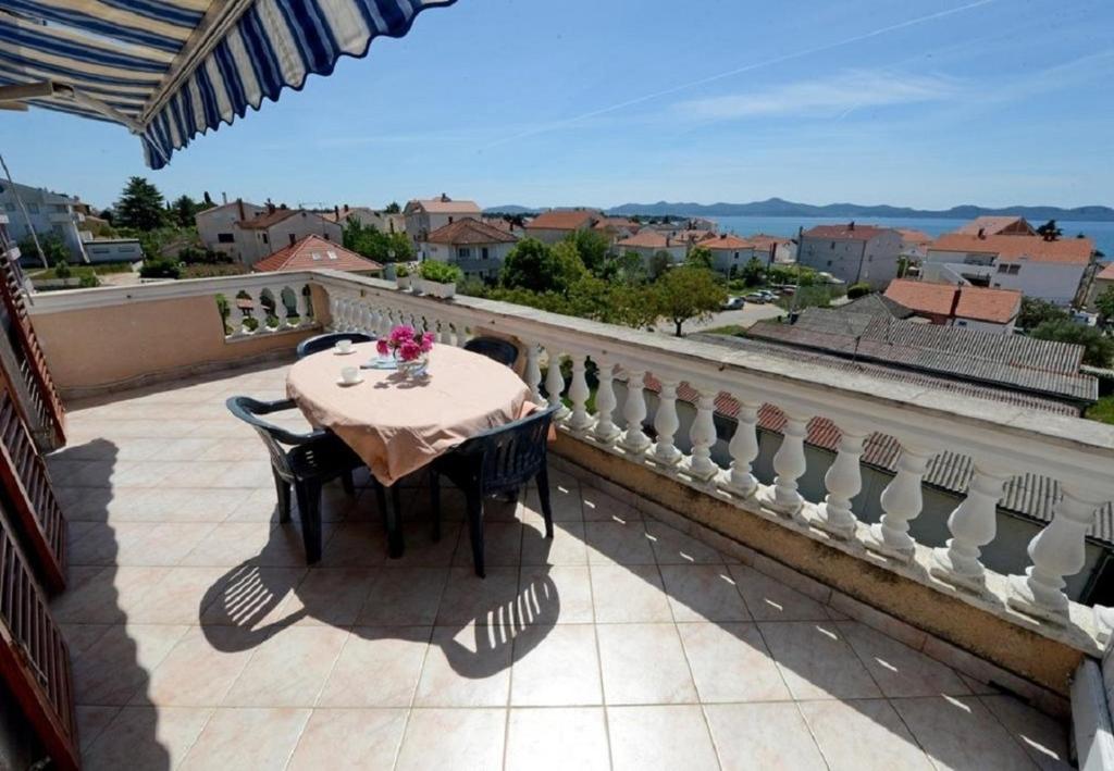 a table on a balcony with a view of a city at Apartments Ankica - 150 m from beach in Zadar