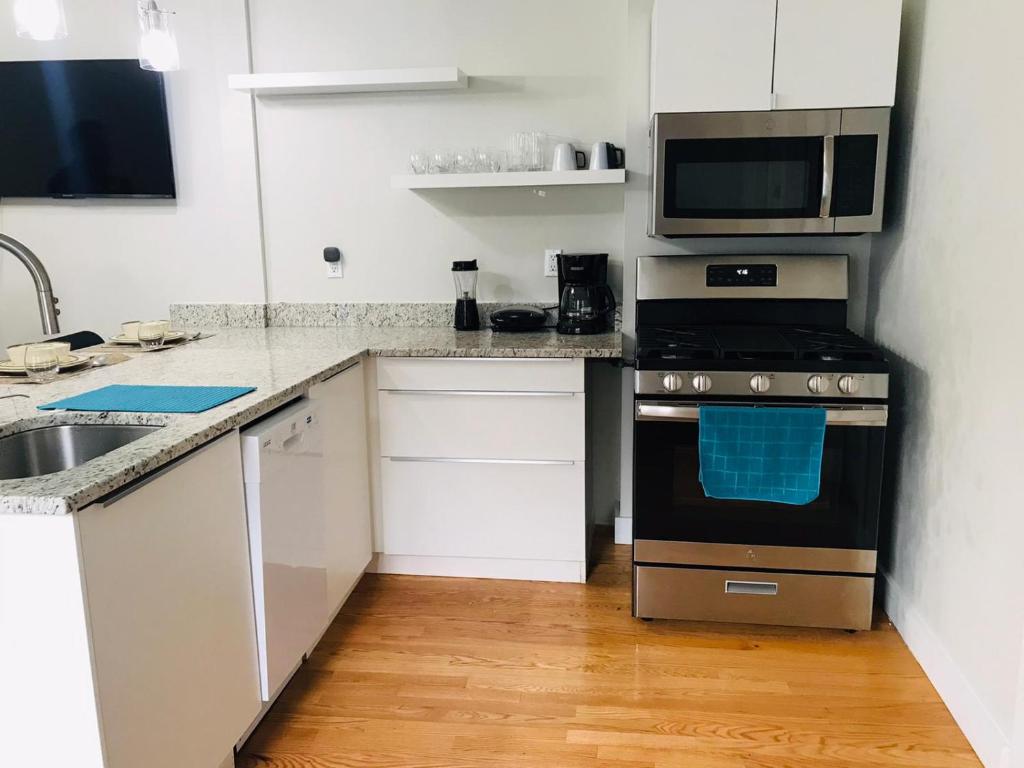 uma cozinha com um fogão e um micro-ondas em Renovated, 10 Min from the city em Boston