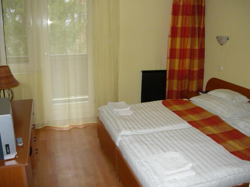 Łóżko lub łóżka w pokoju w obiekcie Ezüstfenyő Hotel